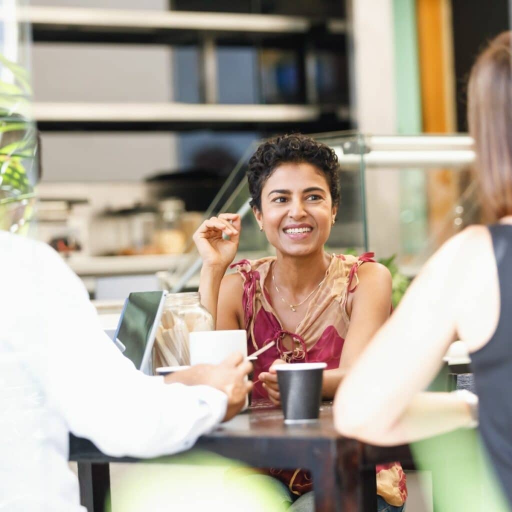 Female smiling, networking with people over coffee