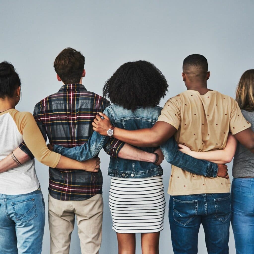 A view of the back of a line of people with their arms on each others backs
